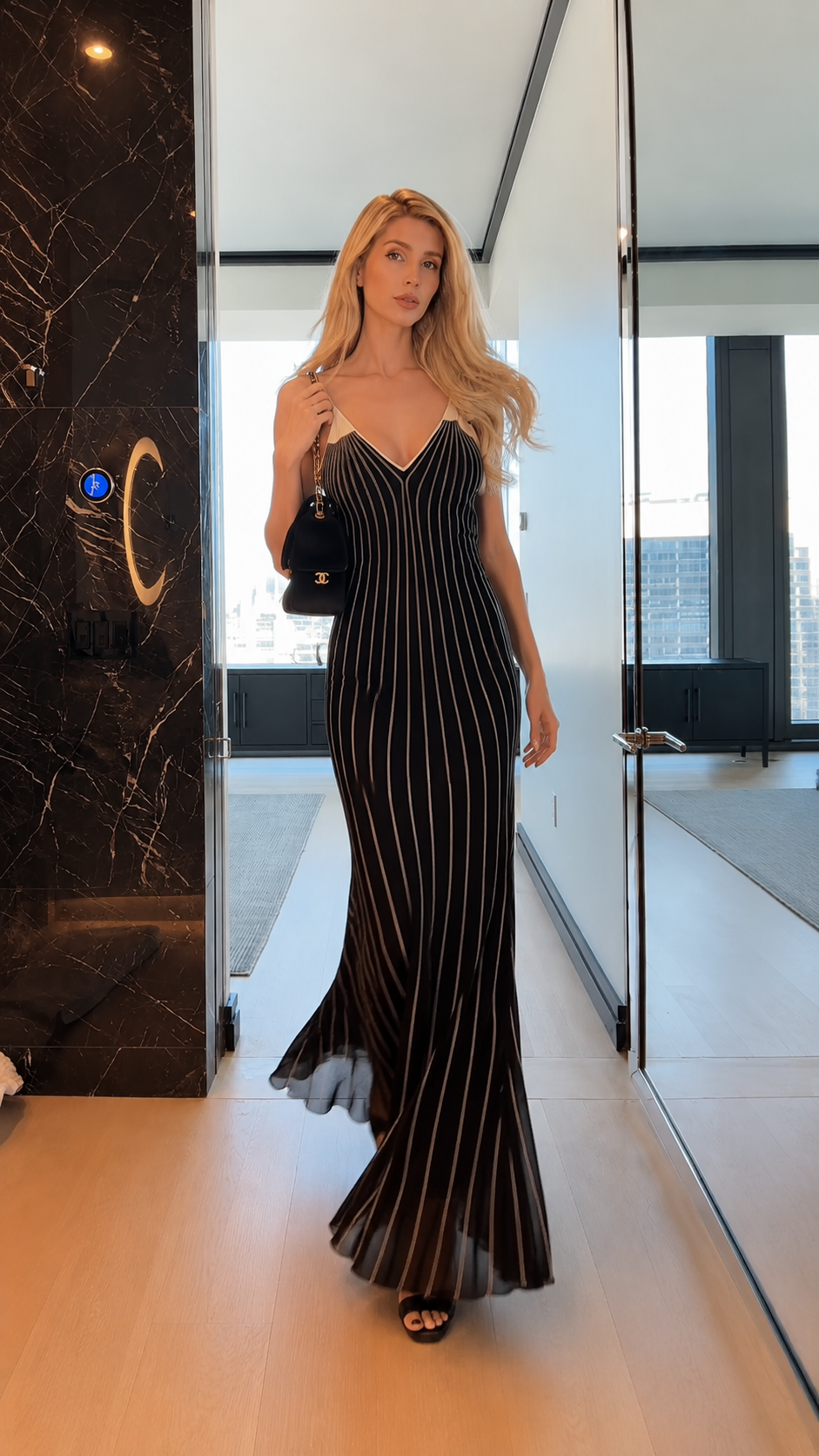 Walking view of black striped body-skimming maxi dress