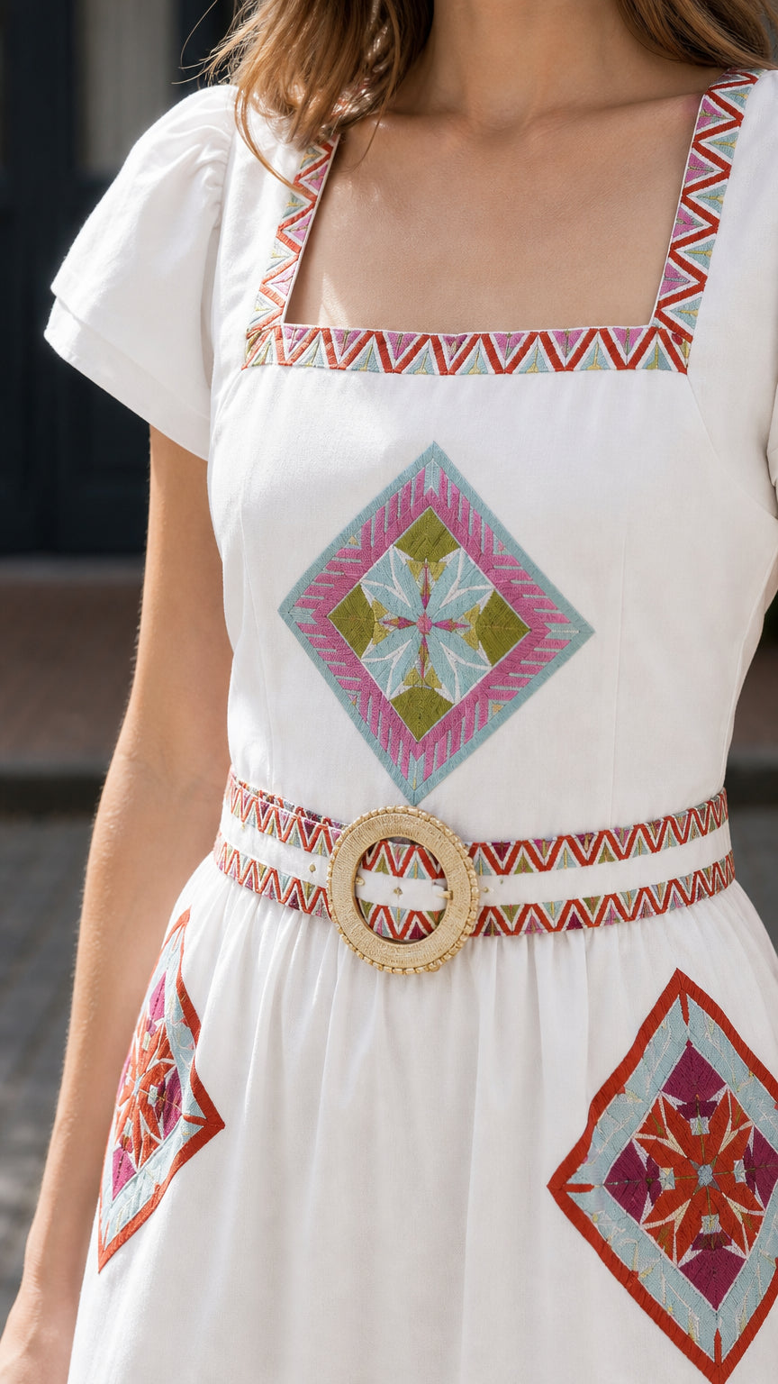 Close-up of embroidery and belt on White maxi dress