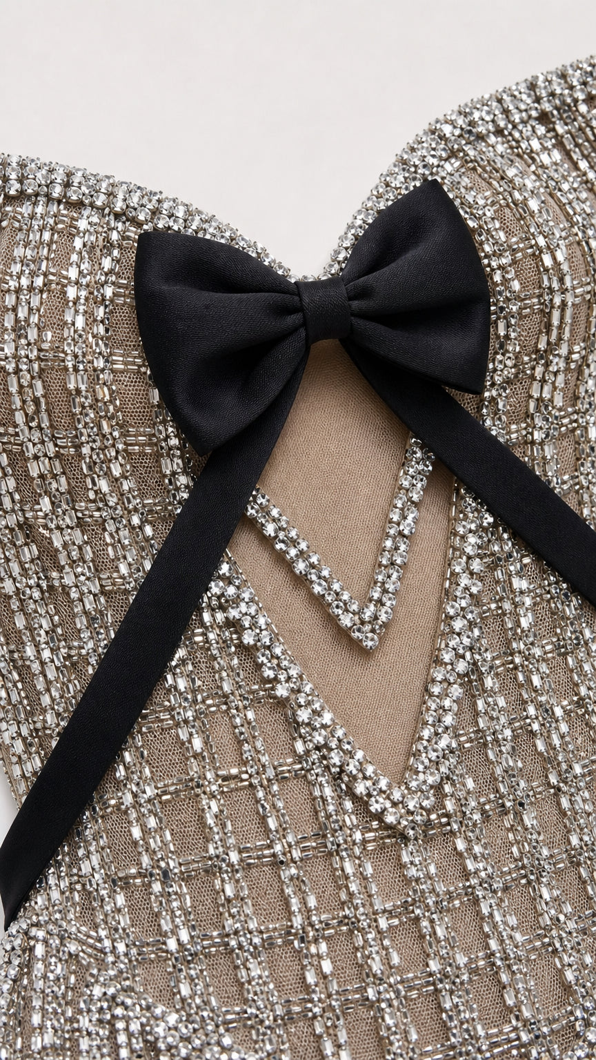 Close-up detail of sweetheart neckline with black satin bow and rhinestone grid texture