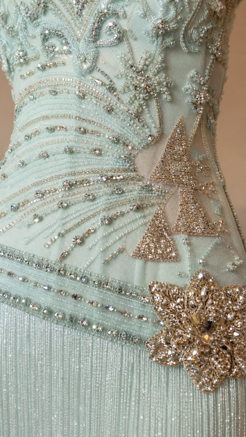 Close-up detail of embroidery and floral appliqué on mint dress