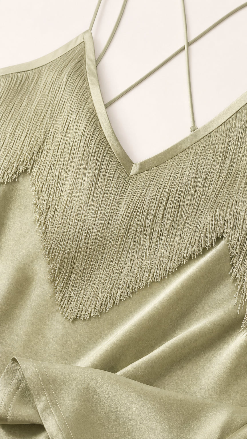 Close-up detail of V-neckline, fringe trim, and delicate straps
