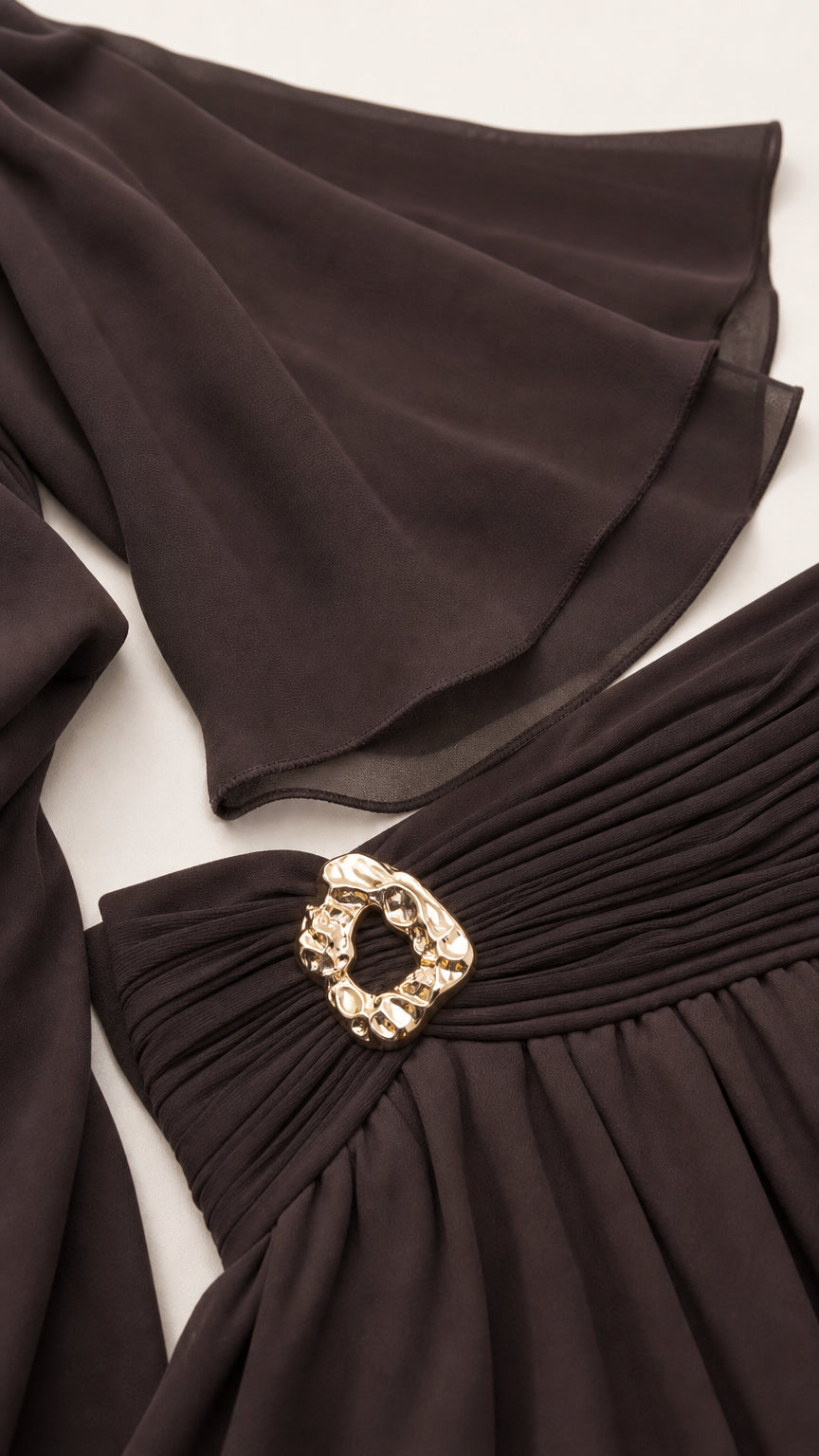 Close-up detail of the wide bell sleeves and ruched waistband with metallic buckle