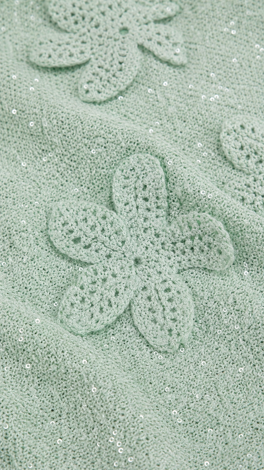 Close-up detail of mint green crochet floral applique and shimmer fabric