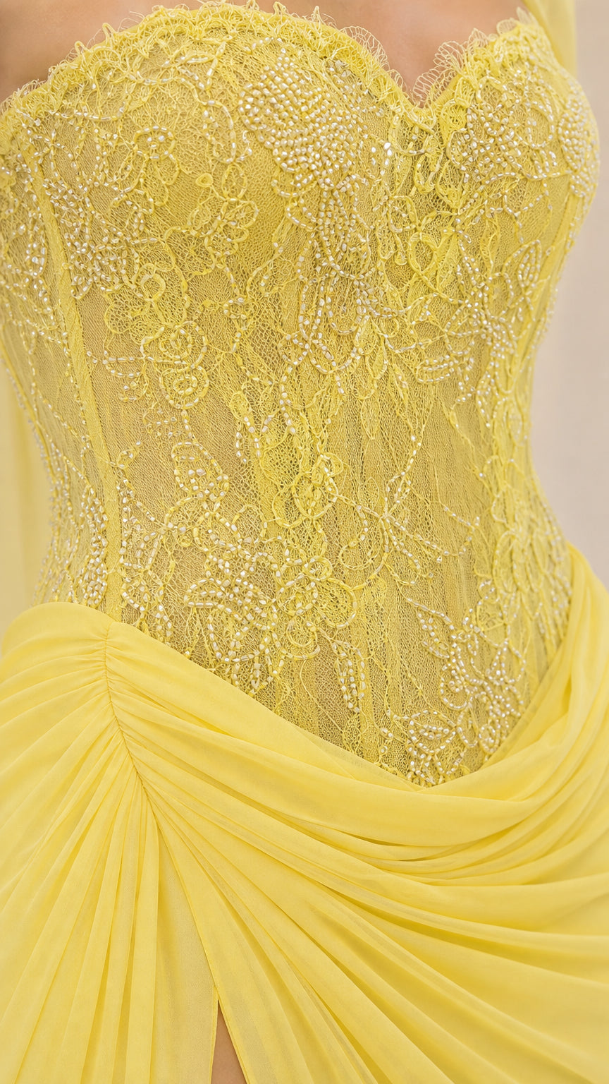 Close-up of the lemon yellow lace-textured bodice and ruched skirt detail