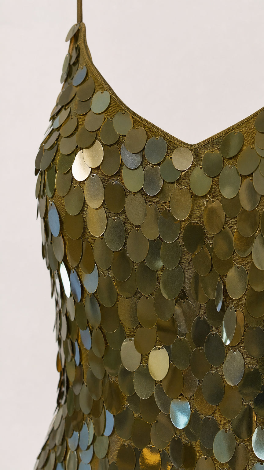 Close-up detail of large disc sequins on olive green dress