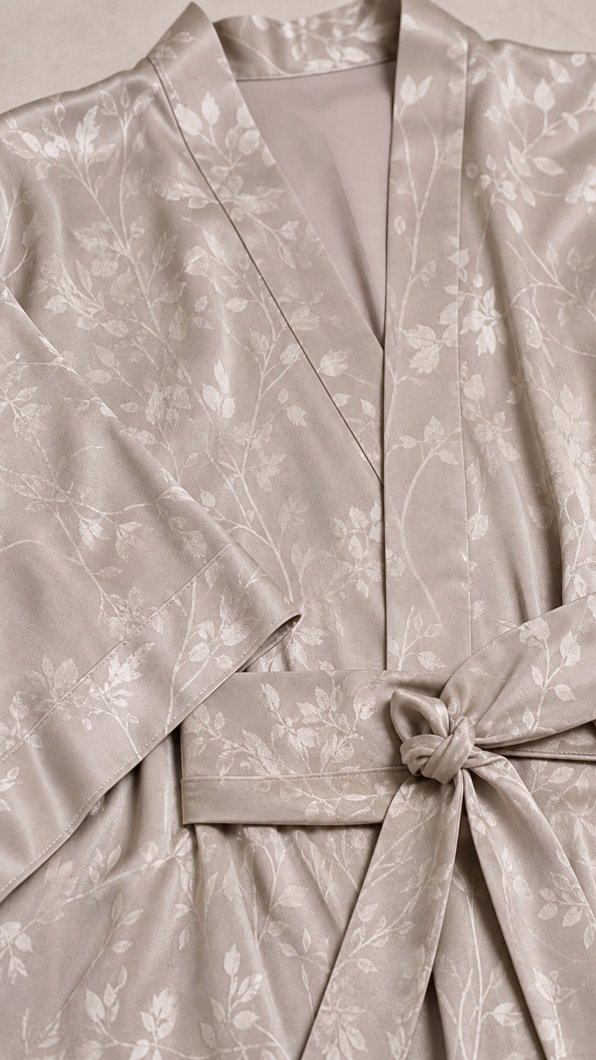 Close-up detail of V-neck and tie belt on champagne satin jumpsuit