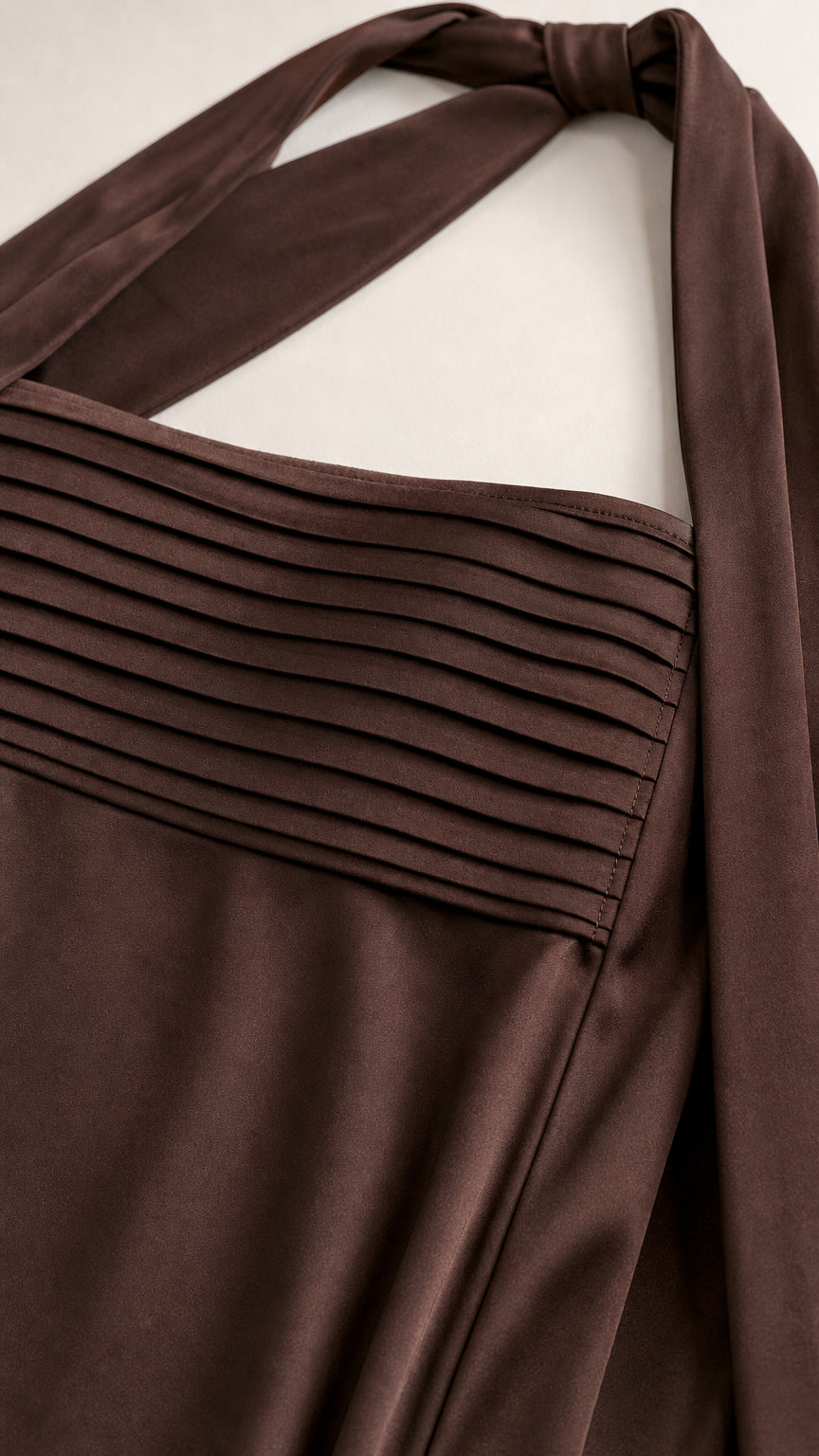 Close-up of pleated bodice and necktie detail in brown