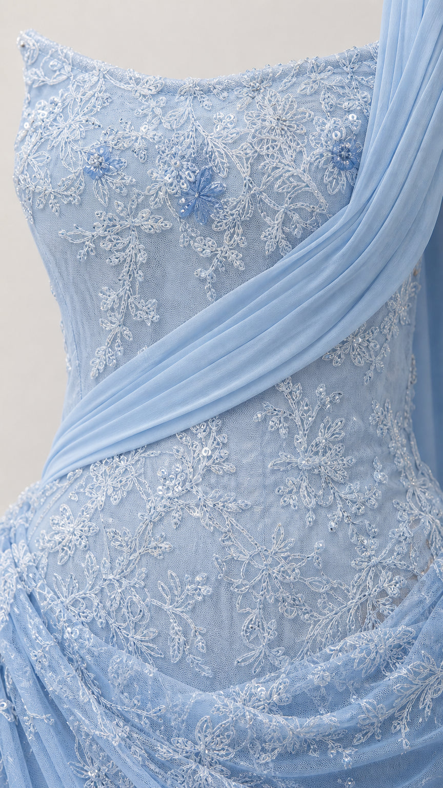 Close-up detail of lace embroidery and draped chiffon fabric