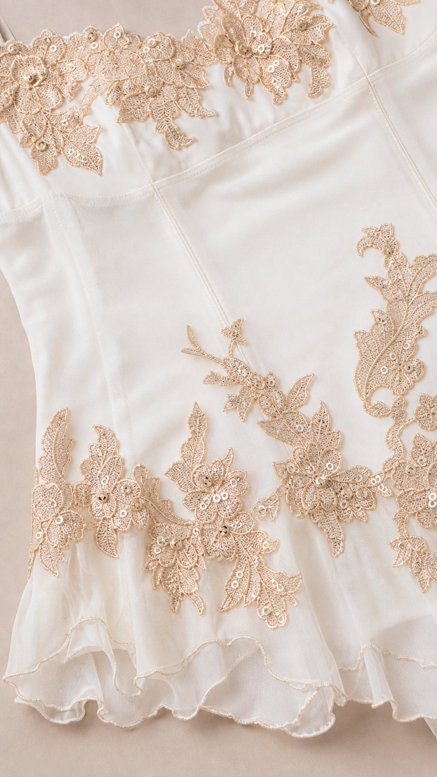 Close up of gold embroidery and sheer hem details
