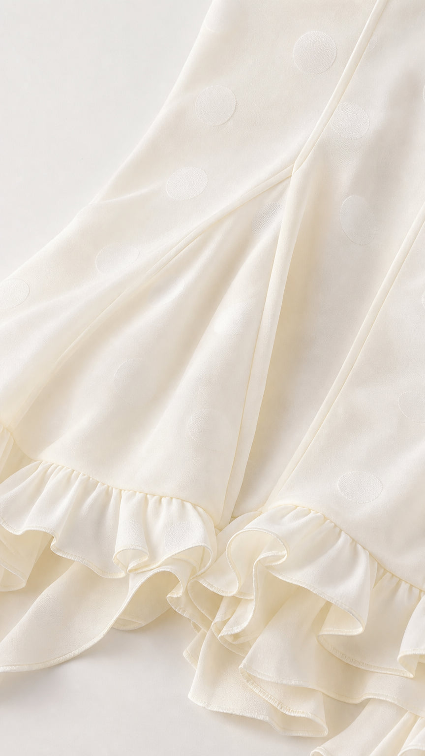 Close-up detail of White dotted fabric and ruffle hem