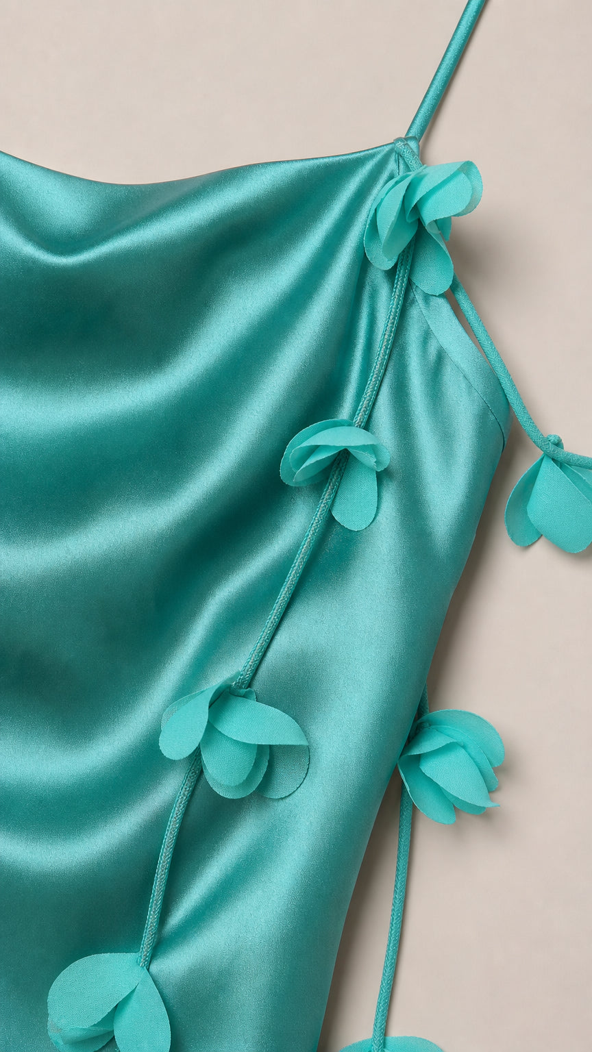 Close-up of fabric and flower strap details on teal dress