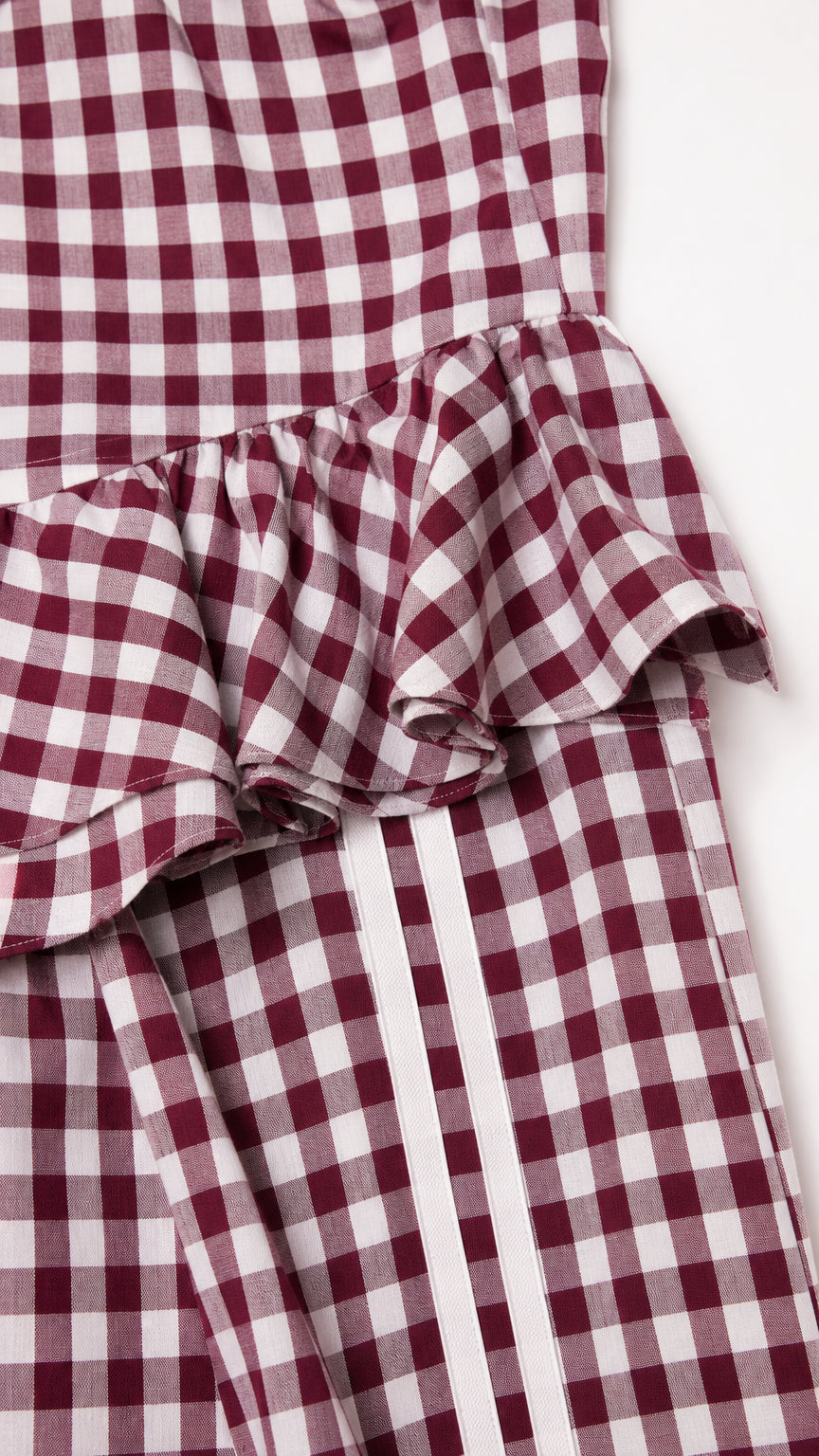 Close-up of peplum ruffle and side stripe detail on burgundy set