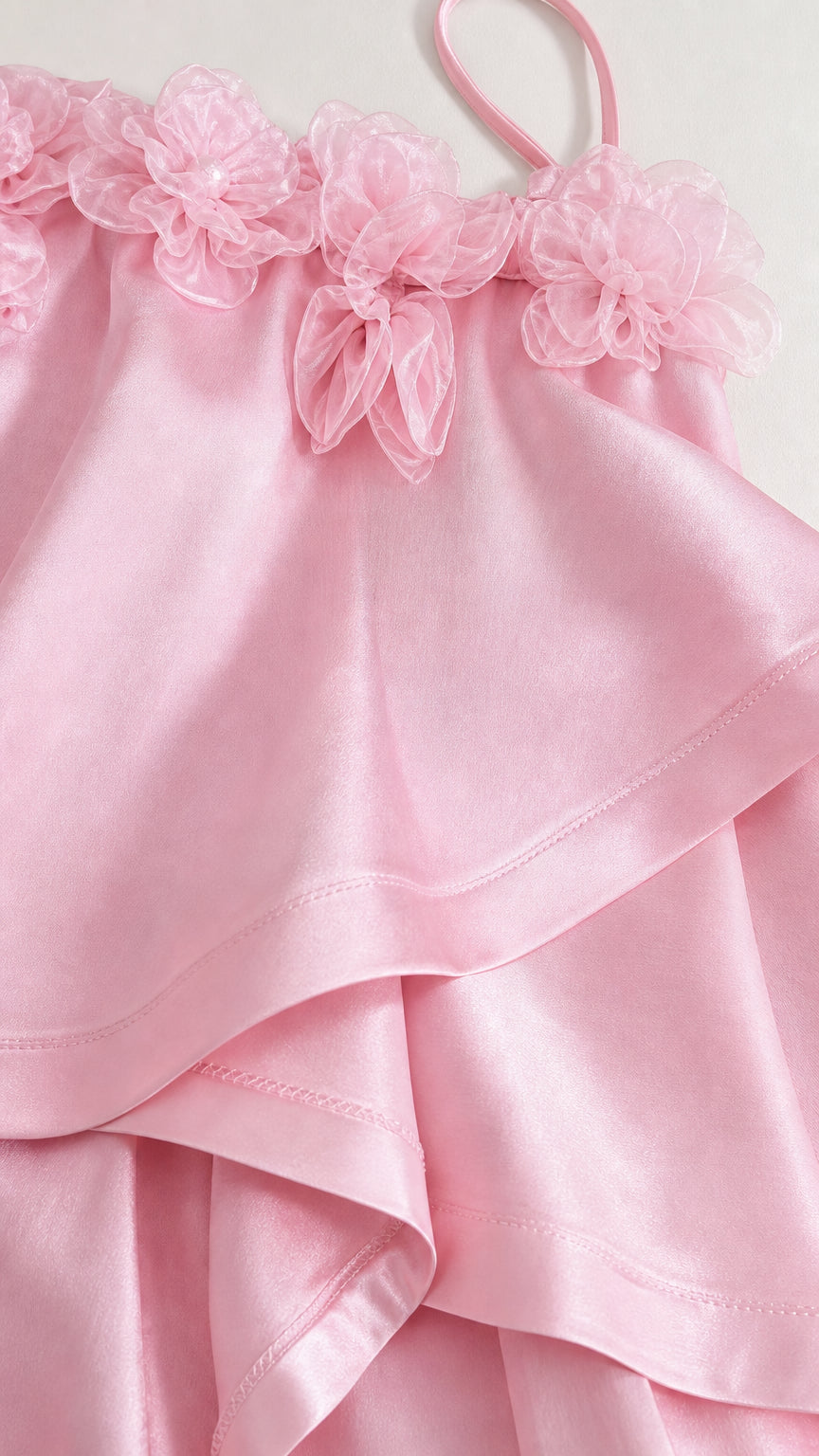 Close-up of pink floral applique bodice and ruffles