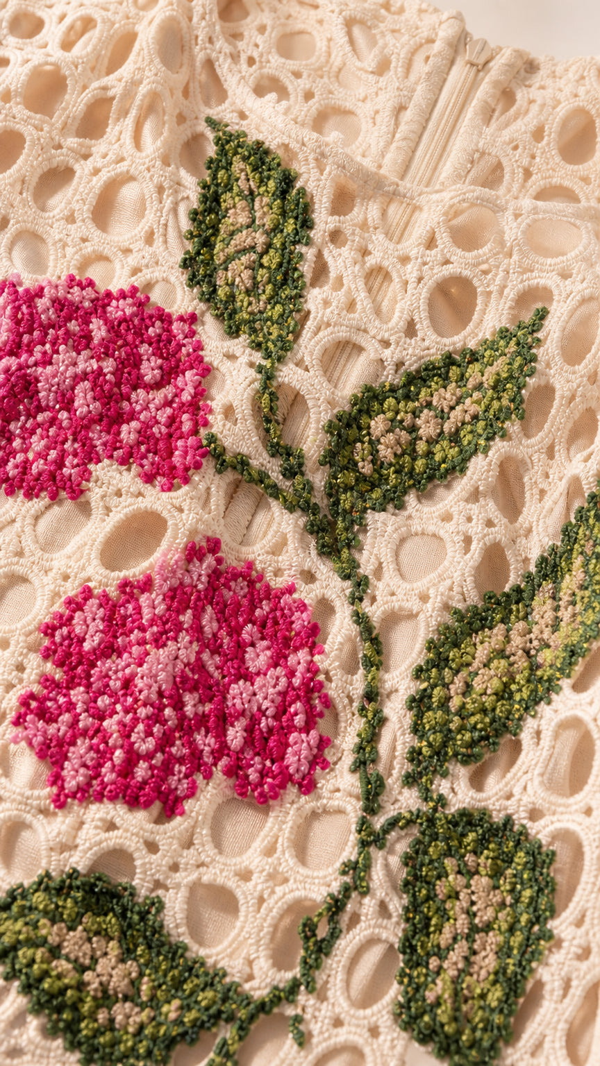 Close-up of textured pink floral embroidery on cutout fabric