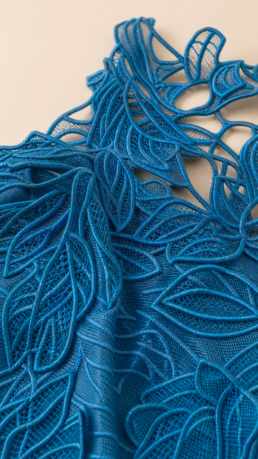 Close-up fabric texture shot of the blue floral embroidery