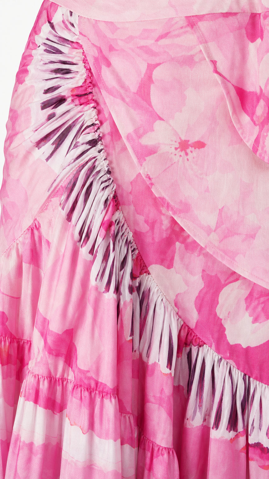 Close-up detail of fabric, ruffles, and tassel trim on pink wrap skirt
