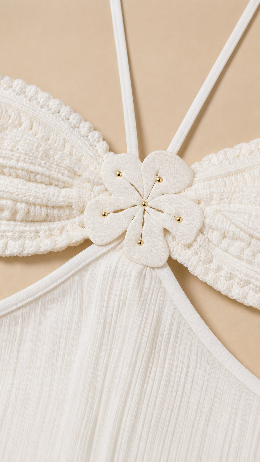 Close-up detail of white bodice with floral appliqué and halter straps