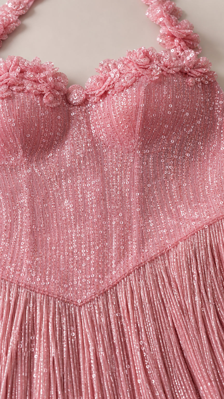 Close-up detail of floral appliques and sequin bodice on pink dress