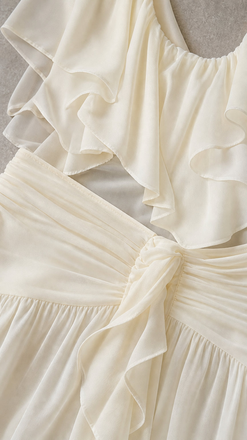 Close-up detail of the ruffled neckline and knotted waist