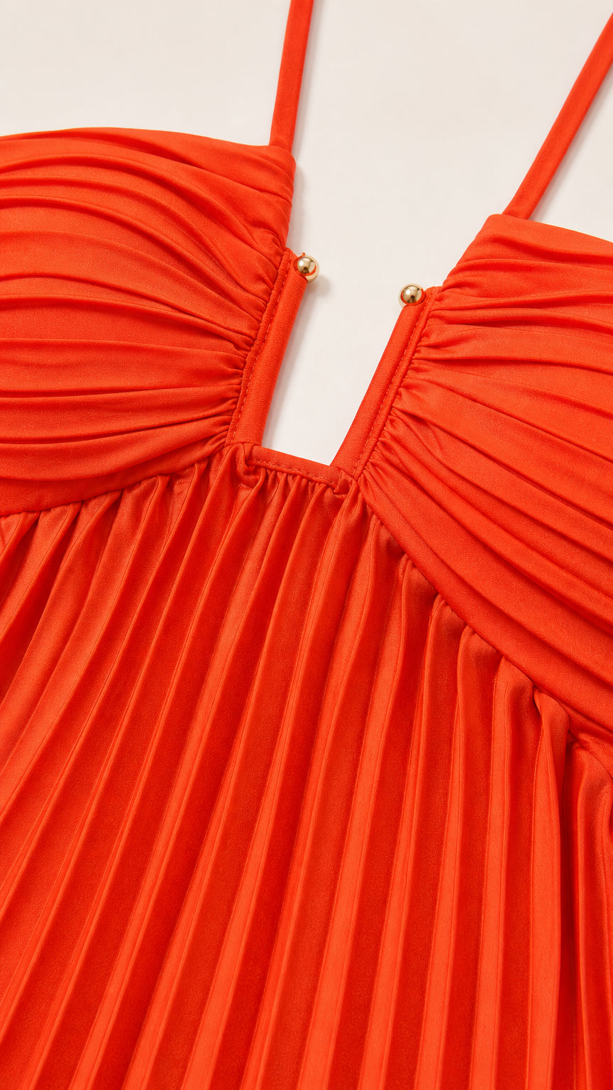 Close-up detail of front plunge neckline and hardware on orange dress