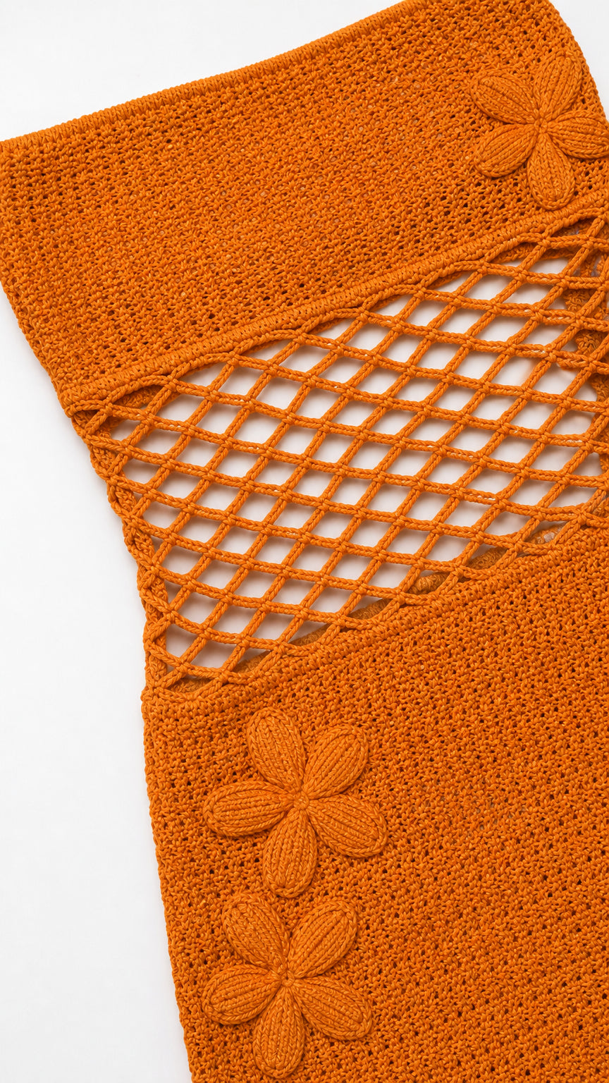 Close-up of orange crochet texture, net cutout, and floral appliques