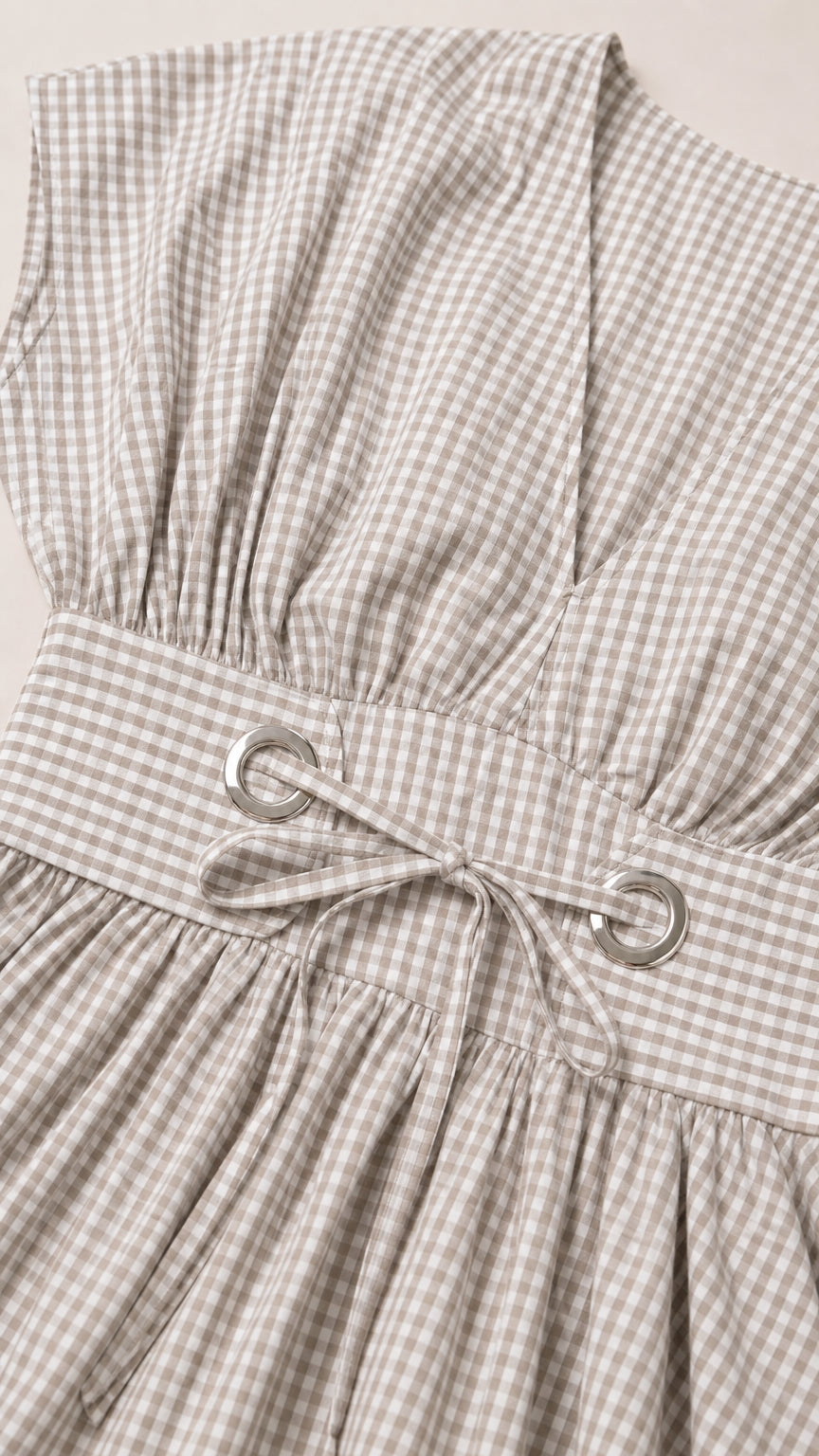 Close-up of bodice, grommet tie waist, and gingham fabric texture