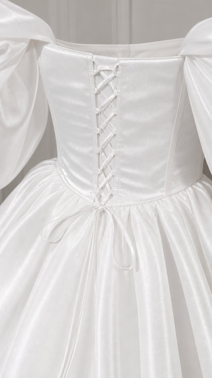 Close-up of lace-up corset back detail on white satin gown