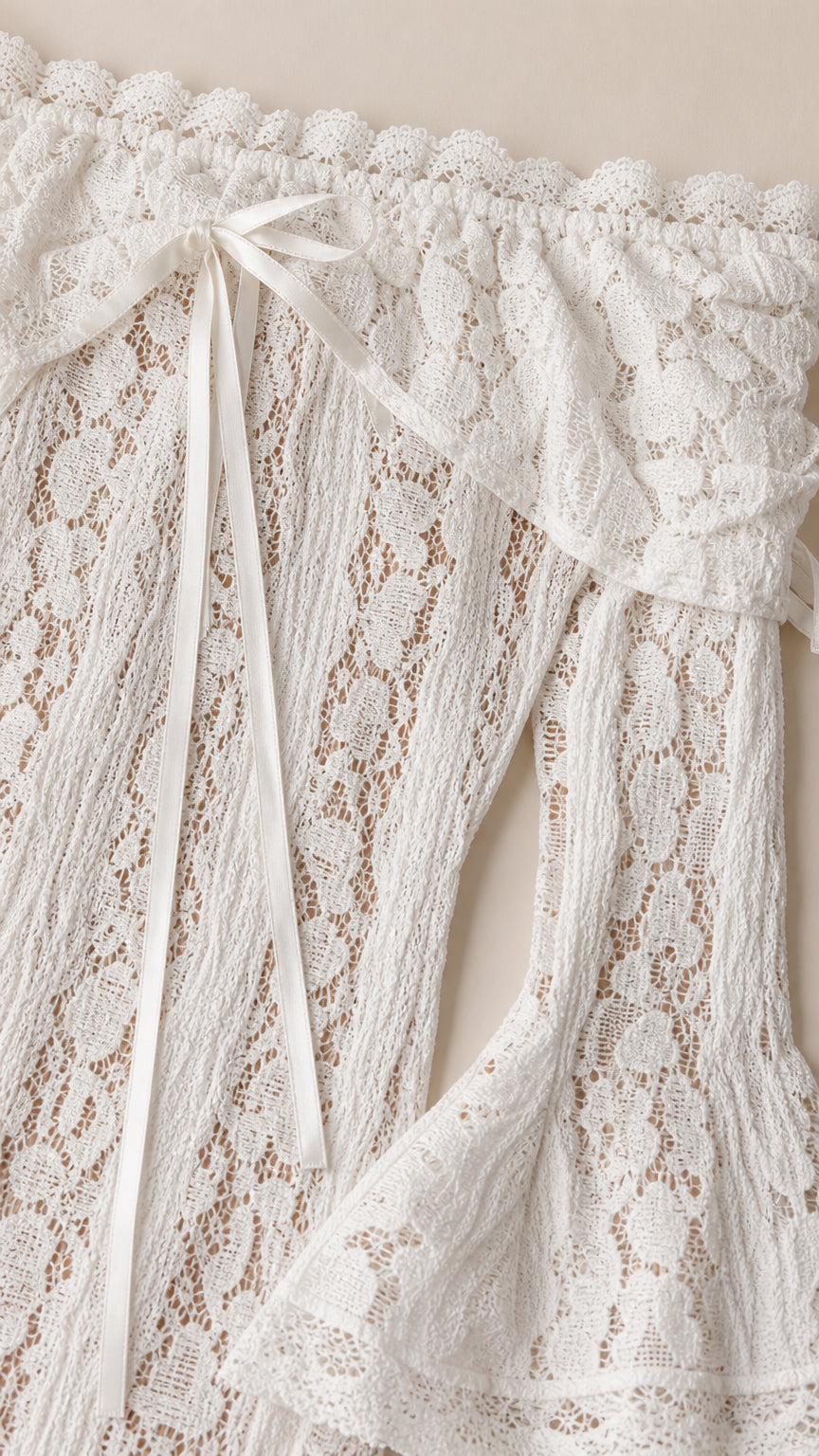 Close-up detail of the white lace fabric, neckline, and bow tie accents
