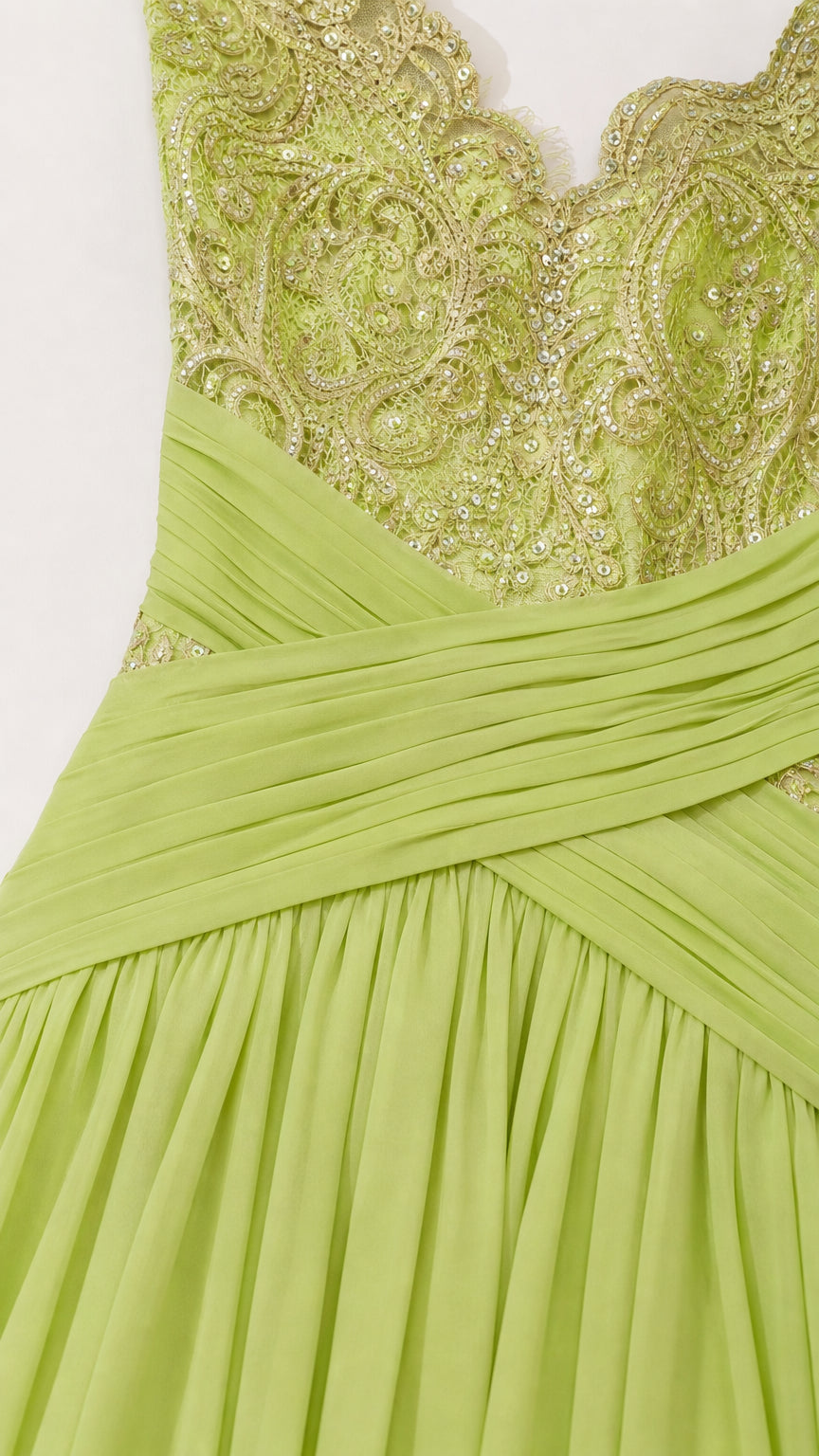 Close-up detail of the embroidered V-neck bodice and wrapped pleated waist