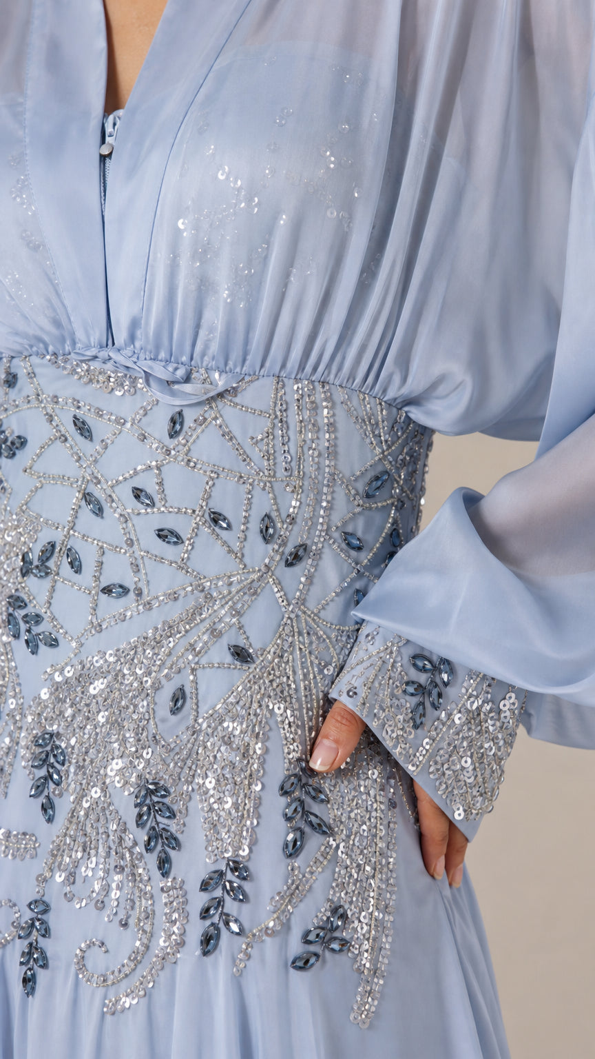 Close-up of beaded waist and sequin cuff details on light blue dress