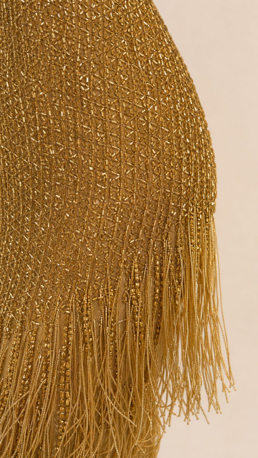 Close-up detail of shimmering beadwork and fringe hem