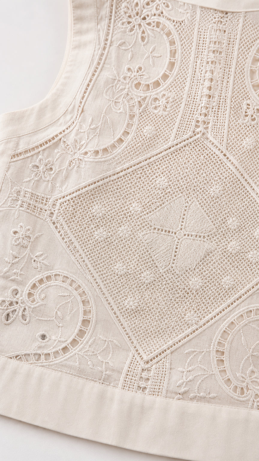 Close-up detail of white embroidered fabric pattern