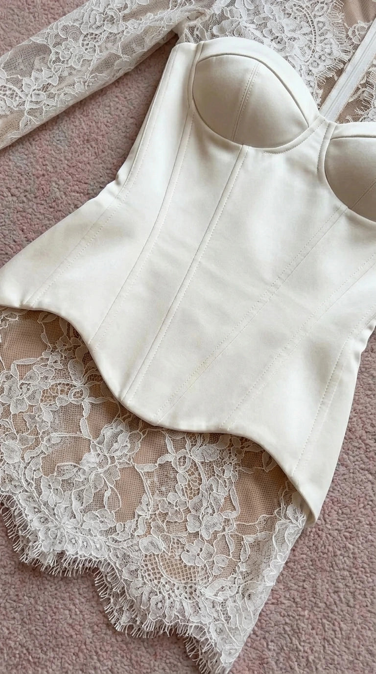 Close-up flat lay detail of white corset bodice and lace hem