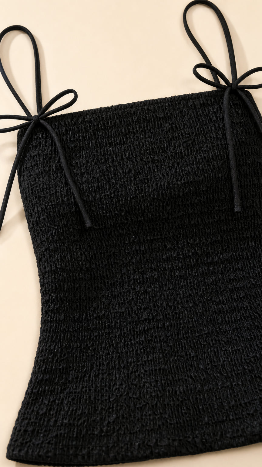 Close-up of black smocked top with tie straps