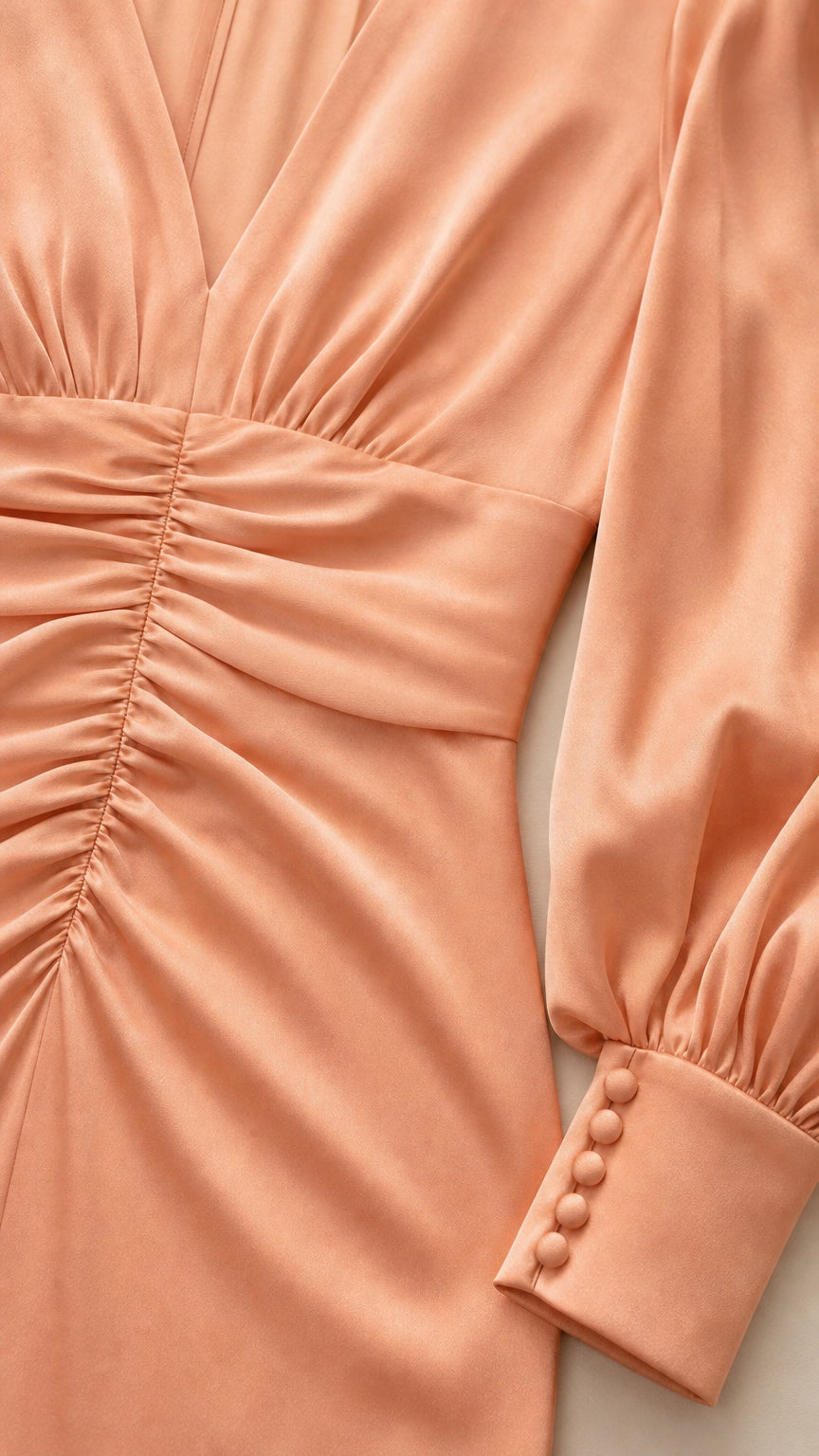 Close-up of ruched bodice and button cuffs on peach dress
