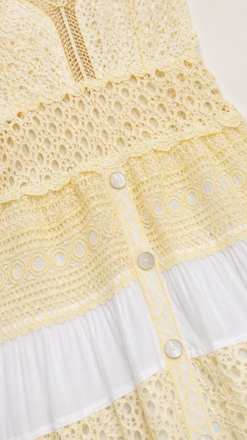 Close-up of crochet and button details on dress