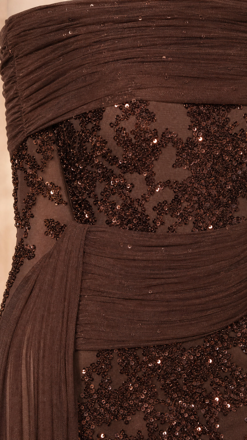 Close up of pleated bodice and sequin detail on brown evening gown