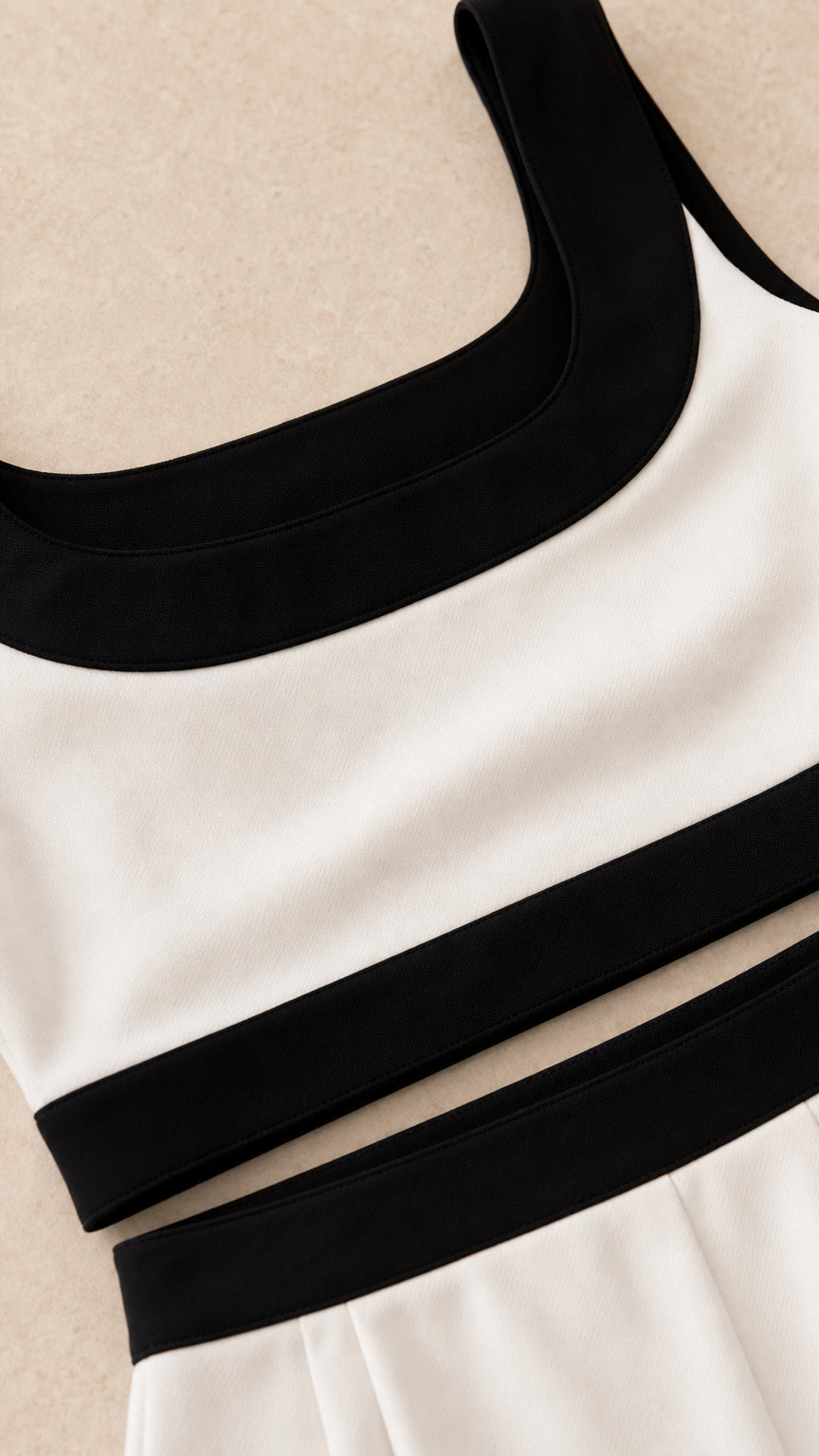 Close-up detail of white top and skirt with black contrast trim