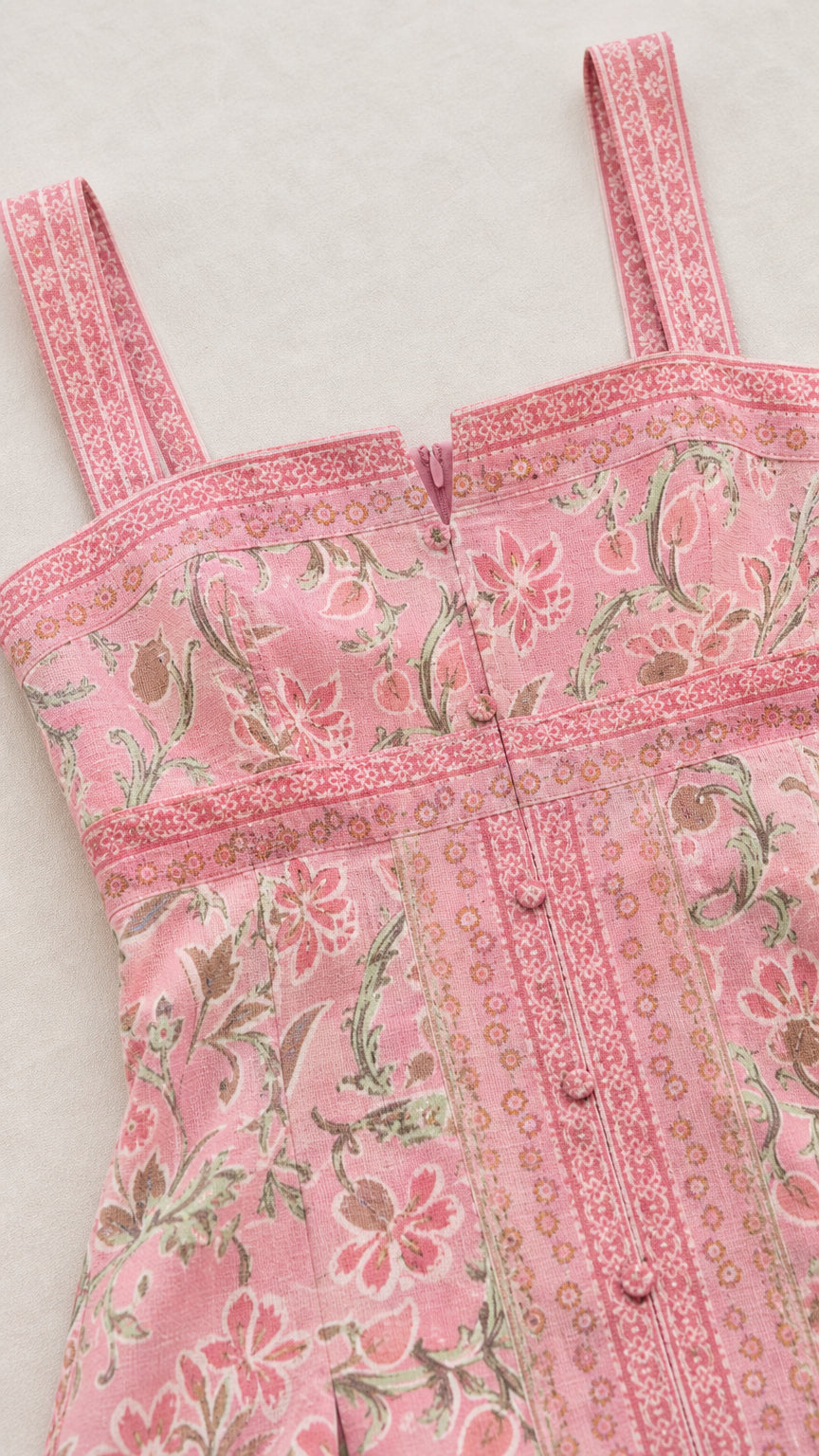 Close-up detail of bodice, straps, and button placket on pink dress