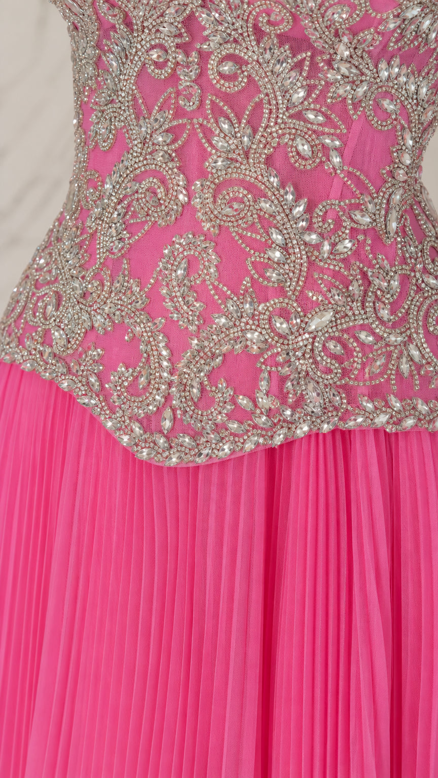 Close-up detail of beaded corset bodice and pleated skirt on fuchsia gown