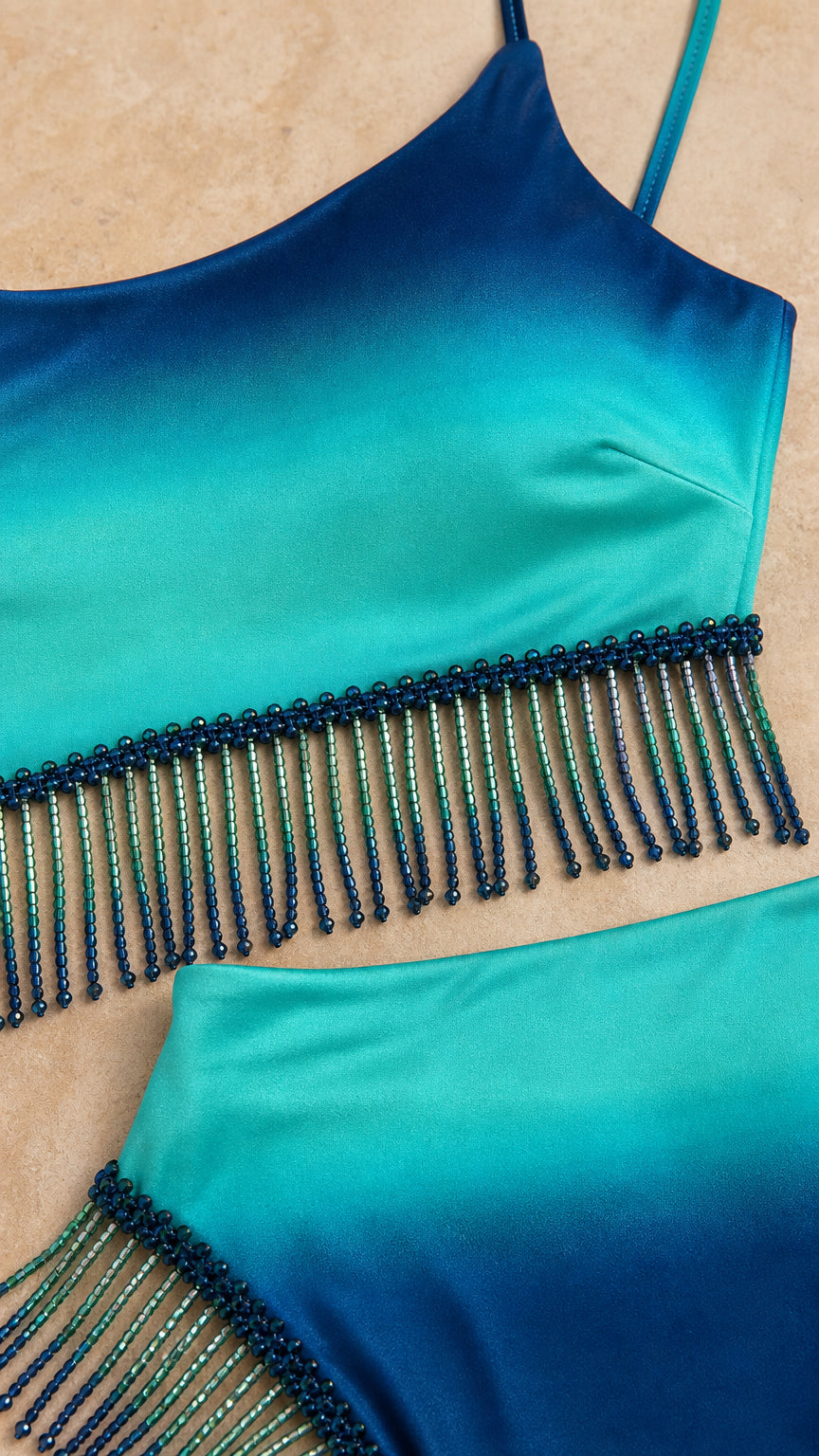 Close up detail of blue ombre satin fabric and beaded fringe trim