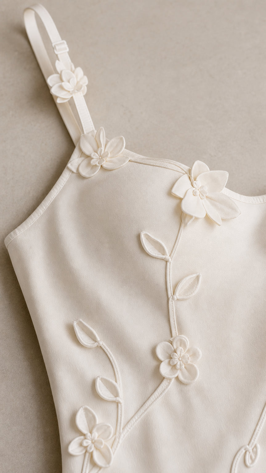 Close-up detail of 3D floral appliques on camisole strap and bodice