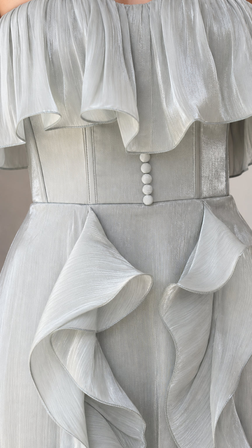 Close-up of bodice, buttons, and ruffle details on the sage green gown