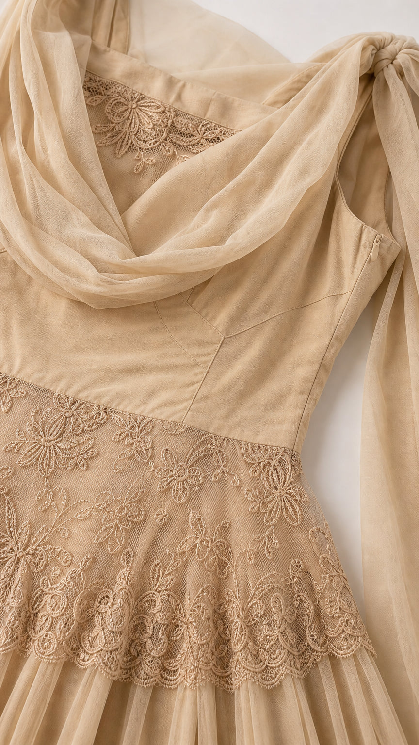 Close-up detail of draped neckline and lace trim on champagne dress