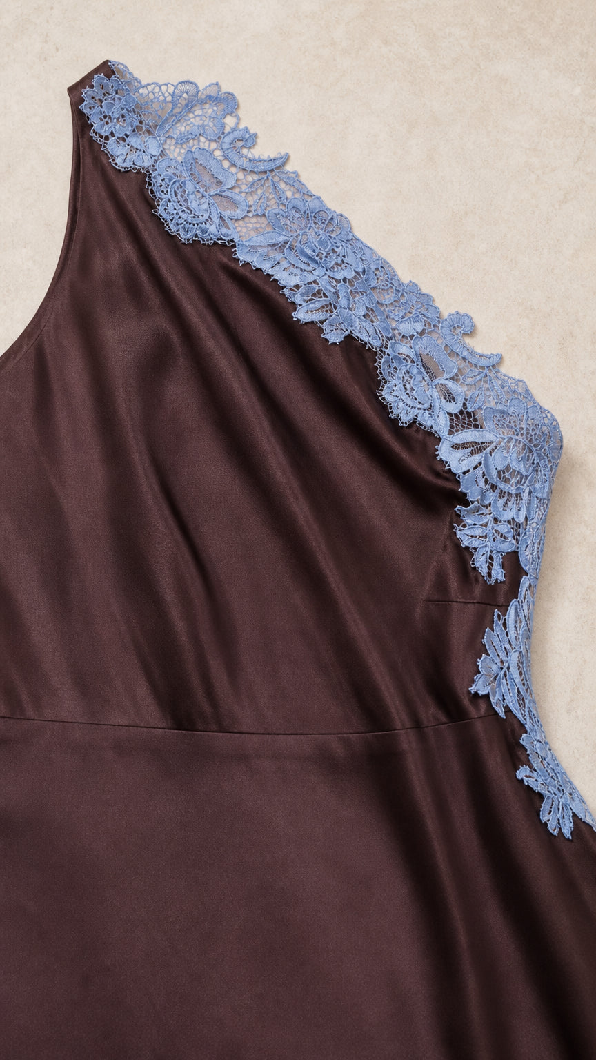 Close-up detail of blue floral lace applique on the shoulder of the brown satin dress