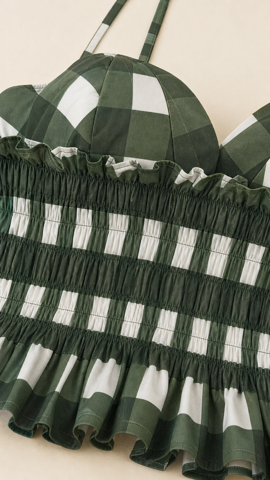 Close up of green gingham smocked bodice and straps