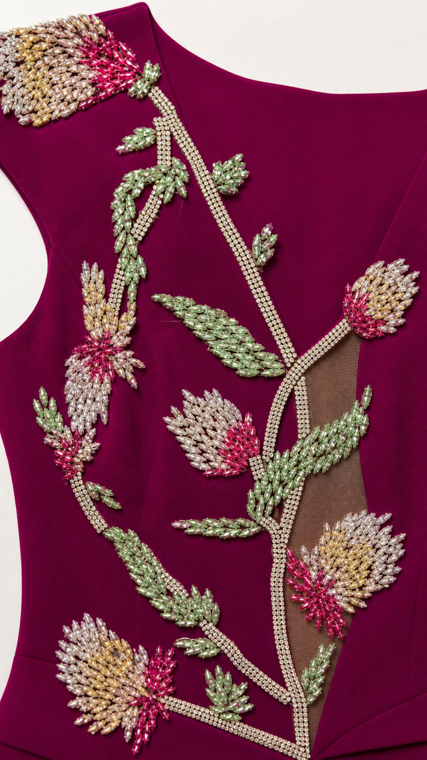 Close-up detail of intricate floral beadwork and sheer accent panel on burgundy dress