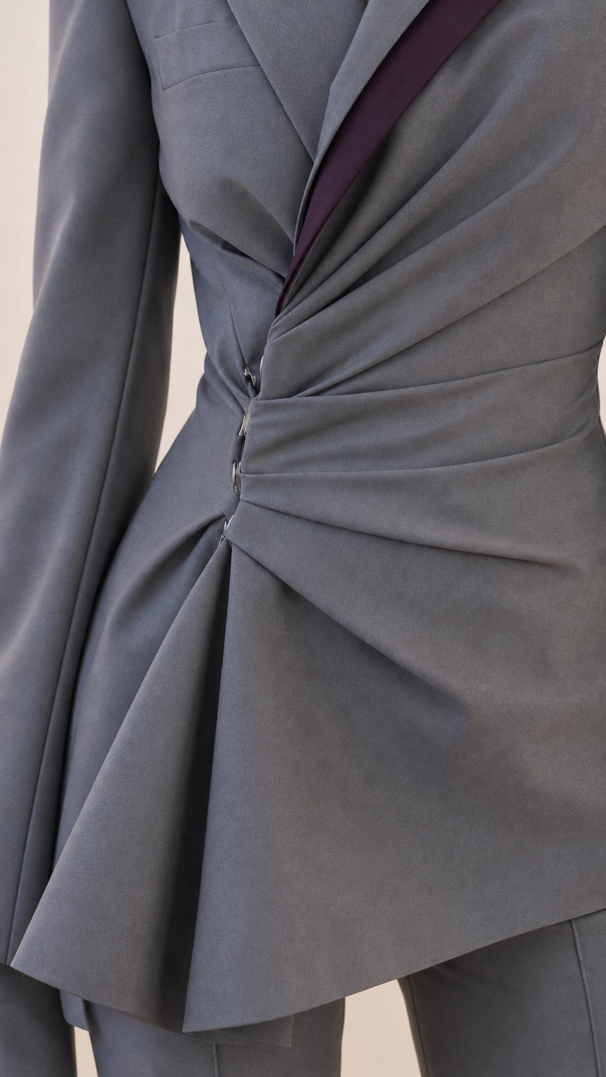 Close-up detail of the asymmetric ruched waist and contrasting lapel