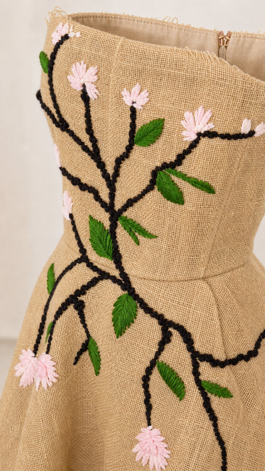 Close up of floral embroidery detail on khaki dress