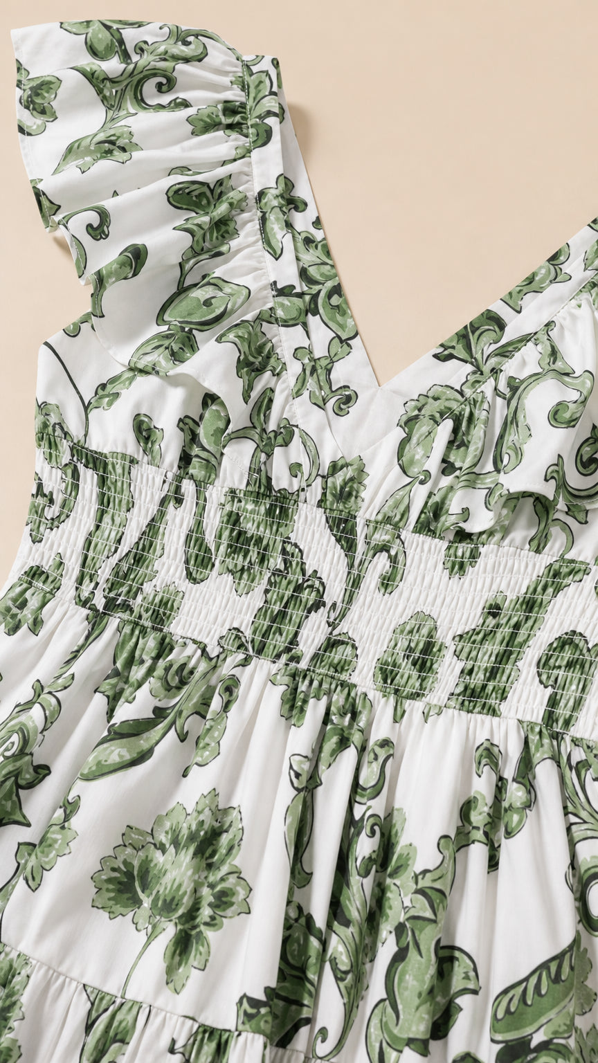 Close up of ruffle shoulder and smocked bodice detail on white floral dress
